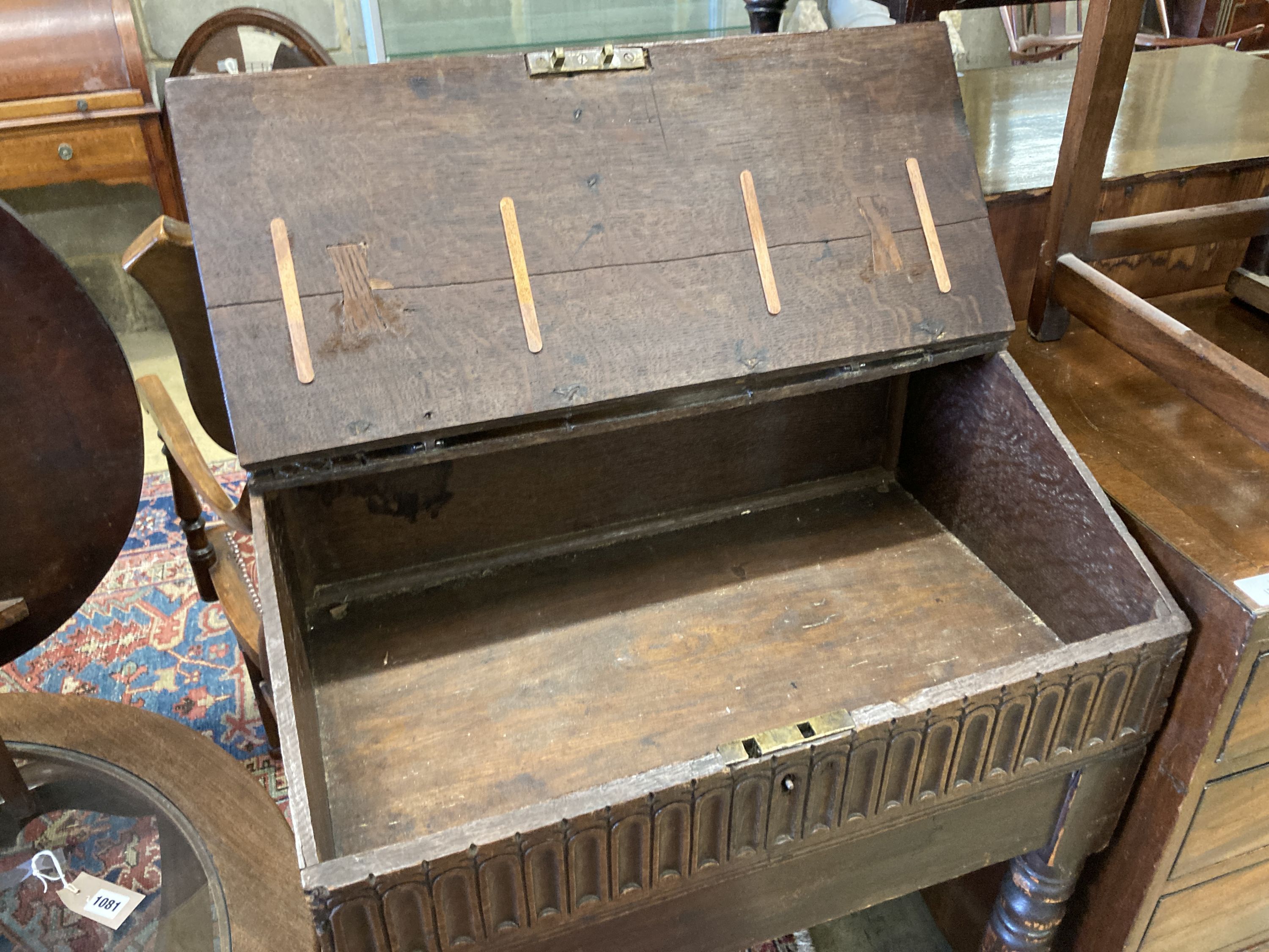 A 17th century oak slant front bible box, raised on a stand